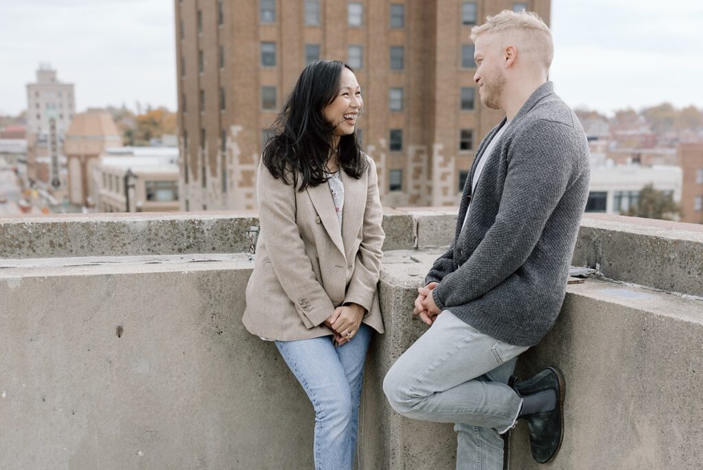 A husband and wife pose on a rooftop in downtown Aurora, Illinois for their family photos taken by Charity White Photography