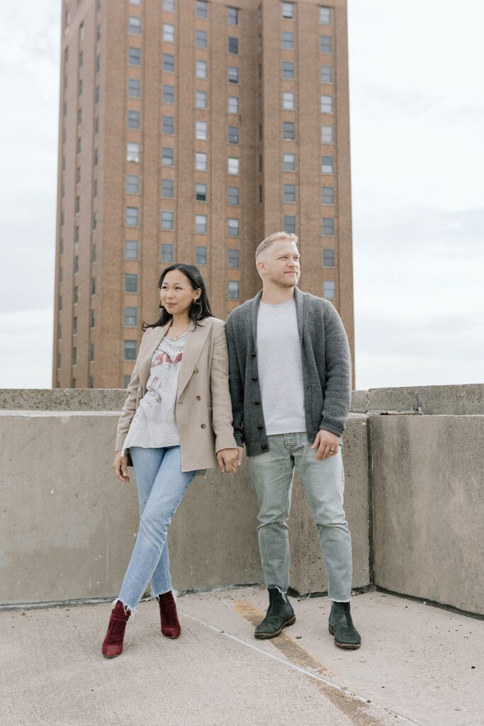 A husband and wife pose on a rooftop in downtown Aurora, Illinois for their family photos taken by Charity White Photography