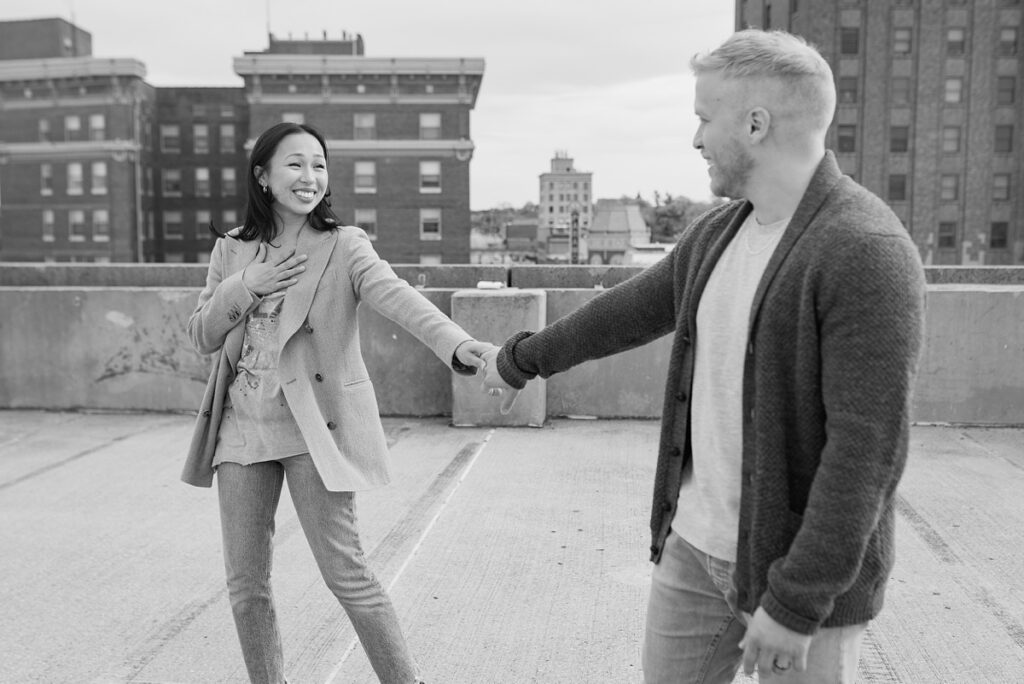 A husband and wife pose on a rooftop in downtown Aurora, Illinois for their family photos taken by Charity White Photography