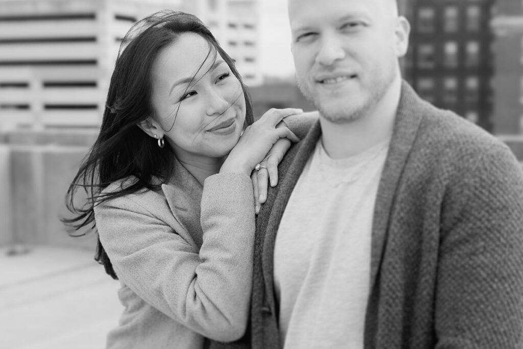 A husband and wife pose on a rooftop in downtown Aurora, Illinois for their family photos taken by Charity White Photography