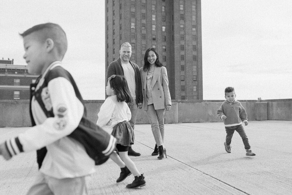 A family with three children poses on a rooftop in downtown Aurora, Illinois for their urban family photos taken by Charity White Photography