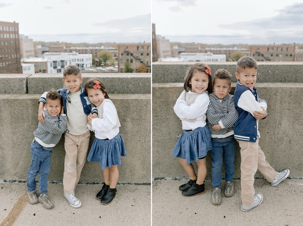 Three children pose for their family photos in downtown Aurora Illinois on a parking garage rooftop