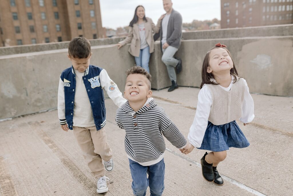 A family with three children poses on a rooftop in downtown Aurora, Illinois for their family photos taken by Charity White Photography