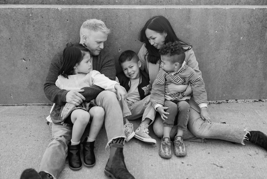 A family with three children poses on a rooftop in downtown Aurora, Illinois for their urban family photos taken by Charity White Photography